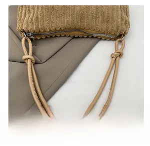 Détail du sac bandoulière en velours côtelé kaki avec sangle nouée en cuir et zip