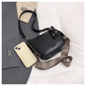 Black leather bucket bag with fashion print and wide woven geometric shoulder strap