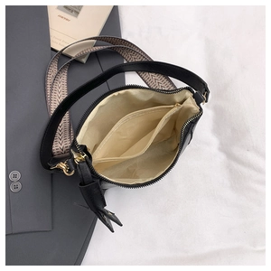 Detail of black bucket bag interior featuring multi-compartment and two adjustable straps