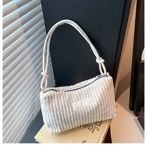 Détail du sac fourre-tout en velours côtelé blanc montrant la texture côtelée et la sangle