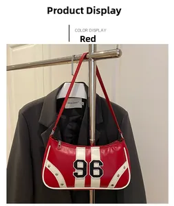 Detail of red racing shoulder bag featuring a 96 patch and silver rivet trim accents