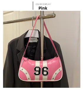 Detail of pink crescent underarm bag with number 96 patch and silver metal rivets