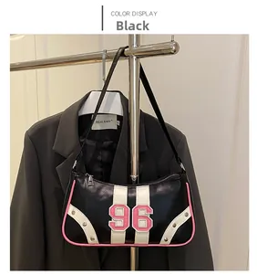 Detail of retro shoulder bag with pink piping, silver rivets, and white 96 numeric patch