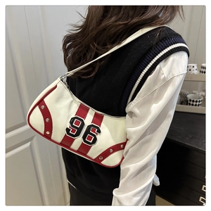 Detail of red and white vintage shoulder bag with large 96 patch and metal rivets