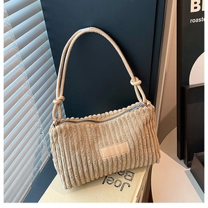 Gros plan d'un sac cabas en velours côtelé marron avec texture côtelée et bandoulière nouée