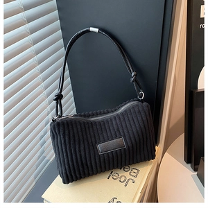 Détail du sac à bandoulière en velours côtelé noir avec sangle en cuir nouée