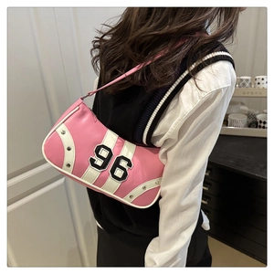 Dettaglio della borsa a spalla rosa e bianca con borchie argento e toppa numero 96