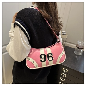 Close-up of pink crescent underarm bag featuring number 96 patch and white trim details