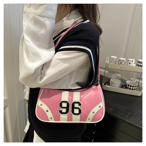 Close-up of pink racing-style crossbody bag with number 96 patch and silver studs