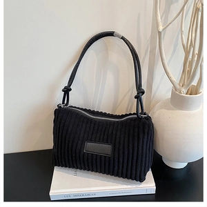 Détail du sac à bandoulière en velours côtelé noir avec fermeture éclair argentée