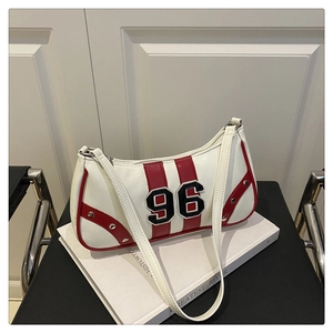 Dettaglio borsa vintage bianca con strisce rosse, toppa 96 e borchie argentate lucide