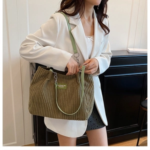 Detail of olive green corduroy tote bag featuring silver chain straps and large capacity