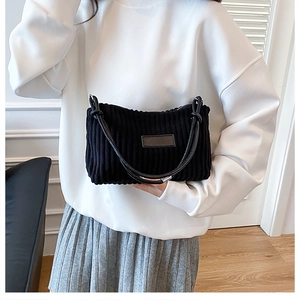 Détail du sac cabas en velours côtelé noir montrant la texture et la bandoulière