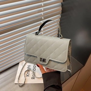 Light blue quilted crossbody bag with silver chain strap and metal turn-lock closure