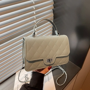 Détail du petit sac à main matelassé vert grisâtre avec chaîne argentée et fermoir pivot