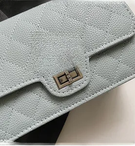 Detail of light blue quilted leather handbag with silver metallic turn-lock closure
