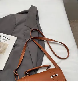 Detail der karamellfarbenen Ledertasche mit silberner Metallschnalle und Trageriemen