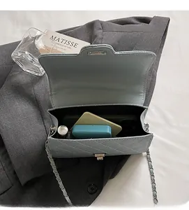 Detailed interior of light blue quilted chain bag showing space for phone and makeup
