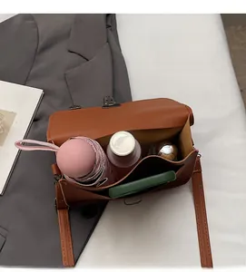 Draufsicht auf das Innere der braunen Ledertasche mit großem Fassungsvermögen für Utensilien