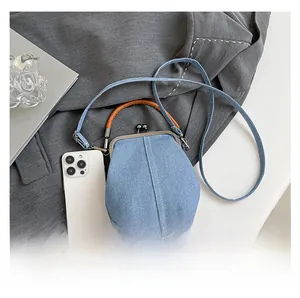 Detailed top view of light blue denim bucket bag with brown leather handles and strap