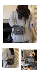 Nahaufnahme der schwarzen Vintage-Tasche mit Metallverschluss und parallelen Riemen