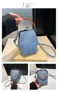 Detail of light blue denim bucket bag with wooden ring handle and metal clasp