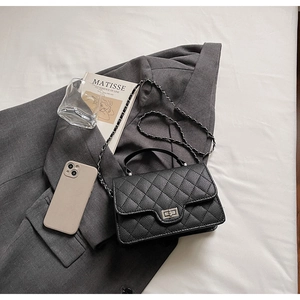 Détail de la texture cuir matelassé et du fermoir argenté sur un sac à bandoulière