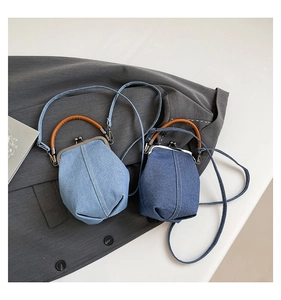 Detail of blue denim bucket bags with silver vintage metal clasp and white stitching
