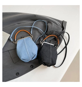 Detail of mini denim kiss-lock bucket bags in light blue and dark grey with leather straps