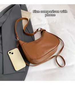 Brown hobo shoulder bag size comparison with a smartphone showing large capacity