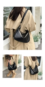 Close-up of black PU leather dumpling bag showing metal ring and stylish knotted strap