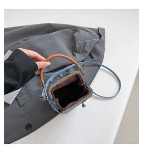 Detailed top view showing open denim bucket bag with brown lining and metal clasp