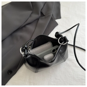 Retro large capacity black shiny shoulder bag showing interior space with phone and wallet