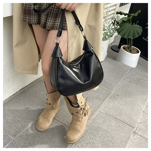 Detail of black crescent shoulder bag with silver zipper and smooth PU leather texture