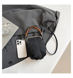 Flat lay of vintage grey denim bucket bag with metal clasp, leather handle and straps