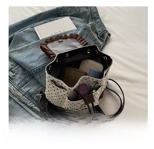 Close-up of drawstring bucket bag showing interior storage for wallet and cosmetics