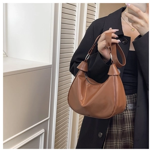 Detail showing the adjustable strap and metal ring connection of the caramel hobo bag
