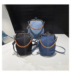 Detail of vintage denim shell bags in three colors with retro metal clasp and leather straps