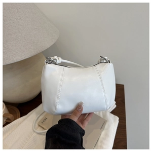 Detail of white PU leather dumpling bag with silver metal zipper and knot handle