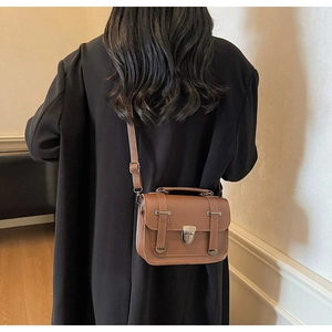 British vintage brown Cambridge bag worn by model over a black long blazer jacket