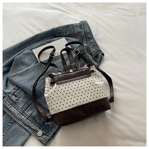 Detail of mini star print backpack featuring brown leather contrast and drawstring closure