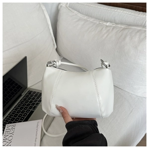 Detail of minimalist white PU leather shoulder bag with silver metallic ring and thin strap
