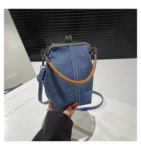 Detailed shot of retro denim bucket bag with metal clasp and brown leather handle