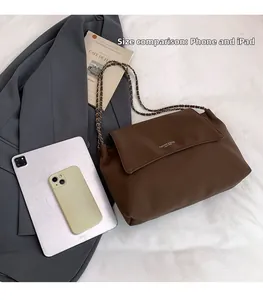 Brown leather chain bag size comparison with smartphone and tablet showing medium capacity