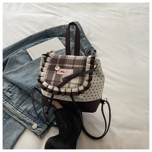 Détail du sac en toile à motif étoiles avec bordure à carreaux et nœud cerise