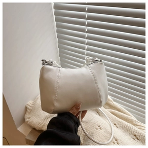 Detail showing smooth white PU leather texture and silver metal ring hardware on the bag