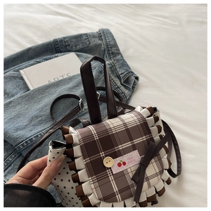 Detail of cute plaid crossbody bag featuring cherry patch, bow, and ruffled lace trim
