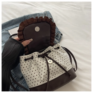Detail of drawstring bucket bag showing magnetic closure and star print pattern