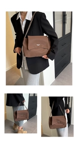 Close-up of brown leather shoulder bag with chic chain strap and minimalist logo detail