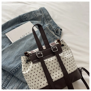 Detail of canvas backpack with star print, drawstring closure and leather trim accents